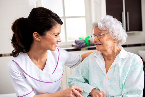 Nurse attending senior woman in a long term care facility, conce